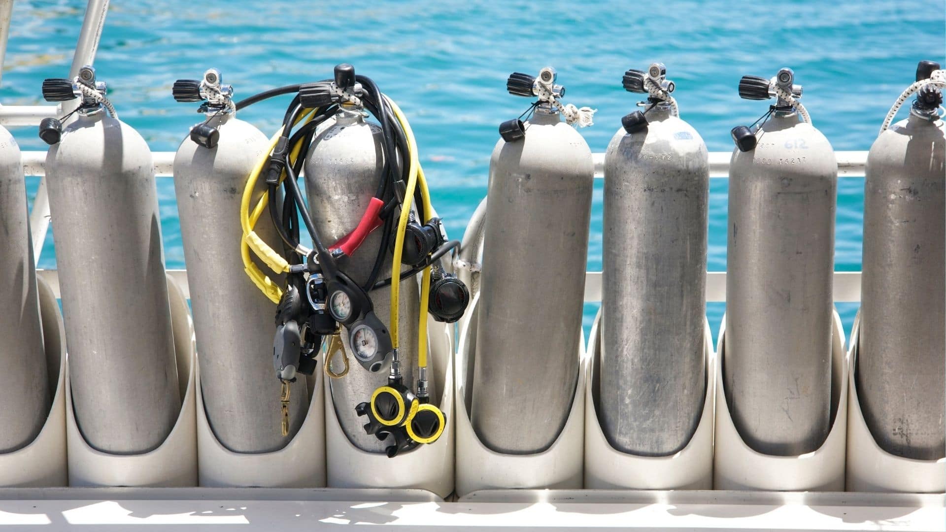 image showing a line of scuba tanks on a dive boat